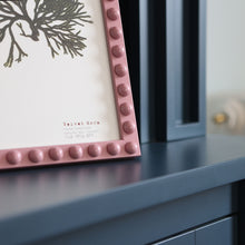 Load image into Gallery viewer, A close up detail of the corner edge of the handcrafted pink bobbin frame in A4 size