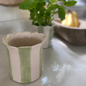 A duo of handmade planters in sage green showing the scalloped edge and delicate inside colours