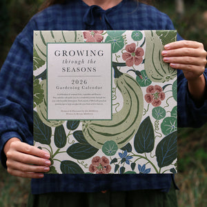 Person holding a 2026 gardening calendar with floral and leaf design