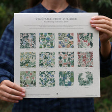 Load image into Gallery viewer, Person holding a 2026 gardening calendar with vegetable, fruit, and flower patterns.