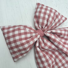 Load image into Gallery viewer, Pink and white gingham bow on a light wooden surface