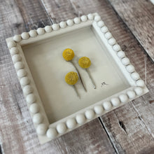 Load image into Gallery viewer, Three yellow spherical billy buttons flowers in a decorative hand painted bobbin frame