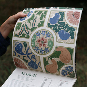 Decorative growing calendar with floral and botanical design held open by a hand.