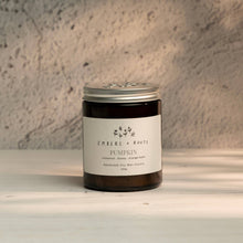 Load image into Gallery viewer, A PUMPKIN SCENTED SOY CANDLE IN A GLASS JAR ON A WOODEN TABLE WITH ROUGH WALL BACKGROUND