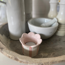 Load image into Gallery viewer, The handmade tealight holder - Daisy in Pastel Pink by Sea Bramble Ceramics on a kitchen counter amidst white bottles for olive oil and vinegar