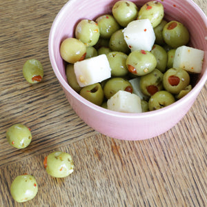 Handmade Barton Croft bowl full of olives and manchego in their distinct and unique Rhubarb glaze