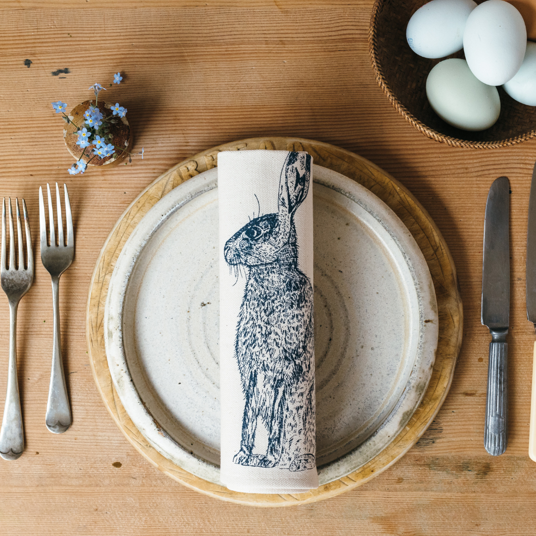 A place setting showing the beautiful blue hare napkin in situ