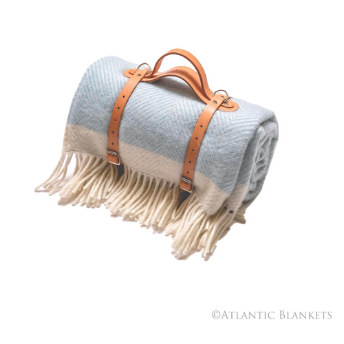Made in Cornwall this is the beautiful herringbone wool picnic blanket in pale blue by Atlantic Blankets.  Complete with leather carry strap