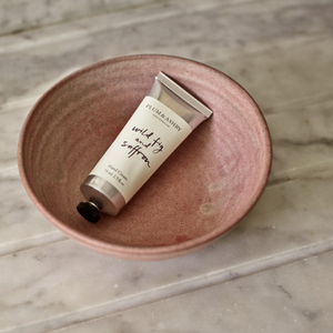 Wild fig and saffron hand cream in a pink bowl